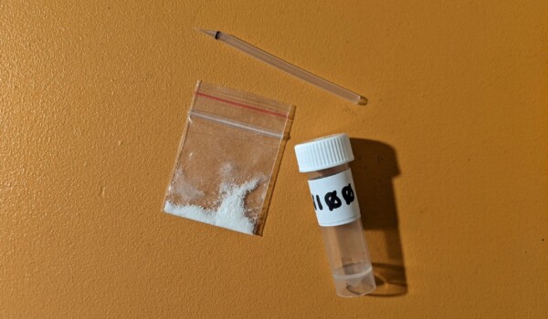 Drug paraphernalia, a small sample of white powder and a sampling container.