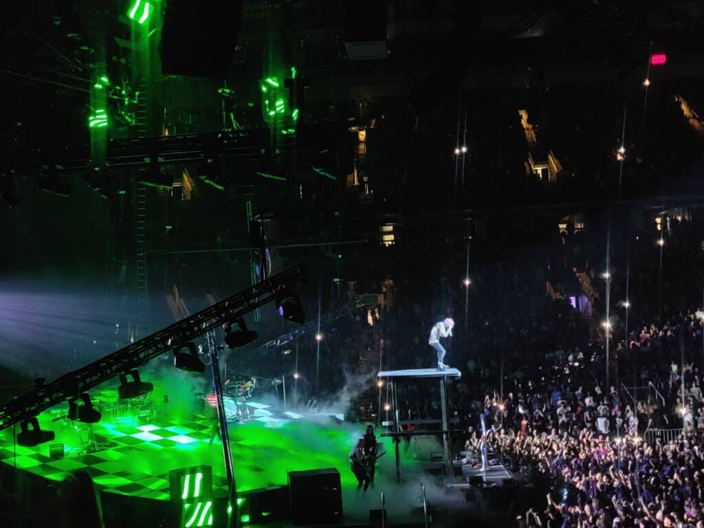 MGK singing on a platform on stage at his concert